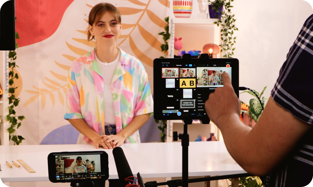 image showing woman in a colorful shirt behind a smartphone video camera, filming content